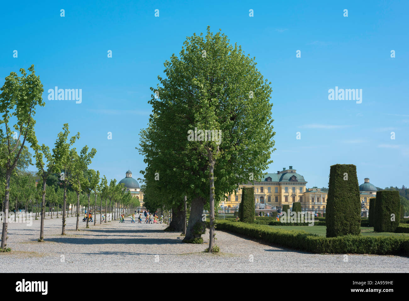Jardin du palais baroque, vue en été de l'avenue bordée d'arbres et le jardin baroque (droite) de l'île de Lovön,de Drottningholm, en Suède. Banque D'Images
