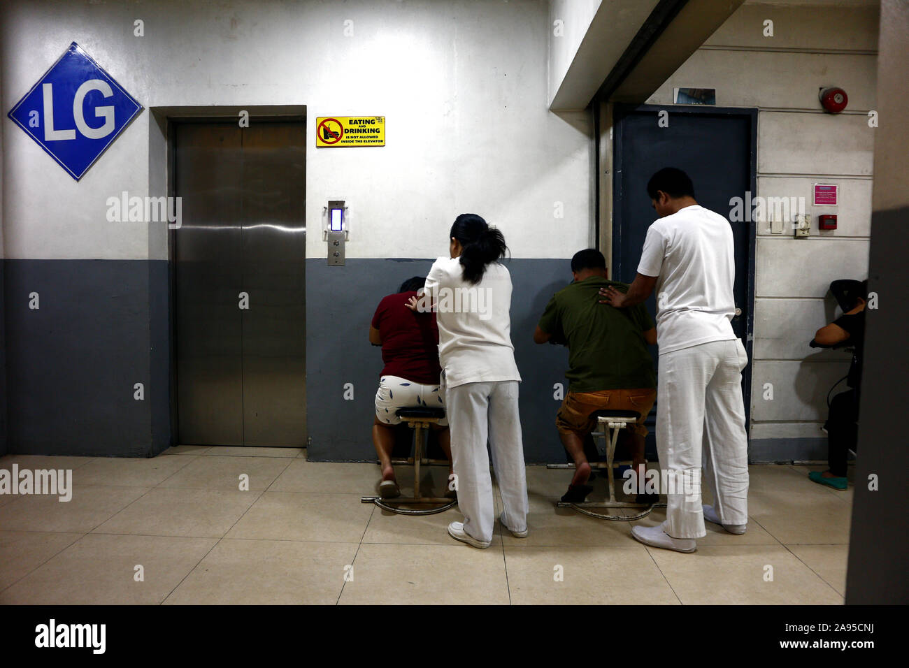 ANTIPOLO CITY, PHILIPPINES - 12 NOVEMBRE 2019 : offre un service de massage masseuse aveugle fatigué de clients à un centre commercial. Banque D'Images