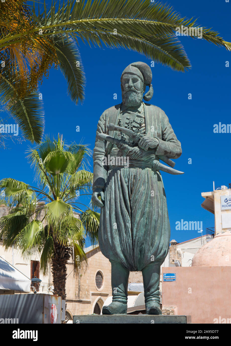 Chania, Crète, Grèce. Statue du combattant de la liberté Anaagnostis Mantakas encadrée de palmiers, Platia Athinagora. Banque D'Images