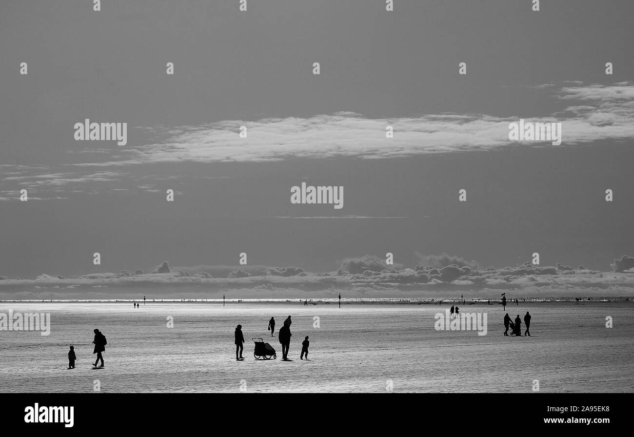 Les gens, des silhouettes dans la mer des Wadden, monochrome, Mer du Nord, à Saint Peter Ording, Schleswig-Holstein, Allemagne Banque D'Images