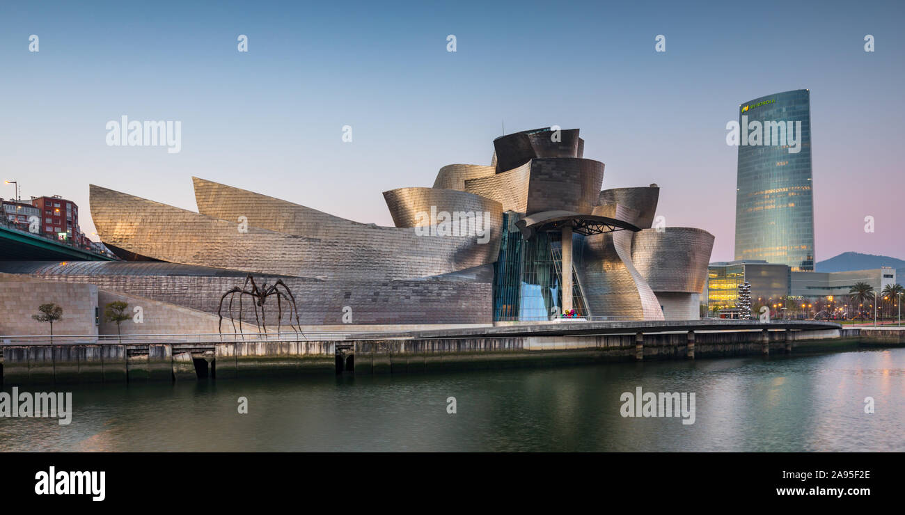 Voir à l'aube de l'autre côté de la rivière Nervion vers le Musée Guggenheim. La tour Iberdrola en arrière-plan, Bilbao, Espagne Banque D'Images
