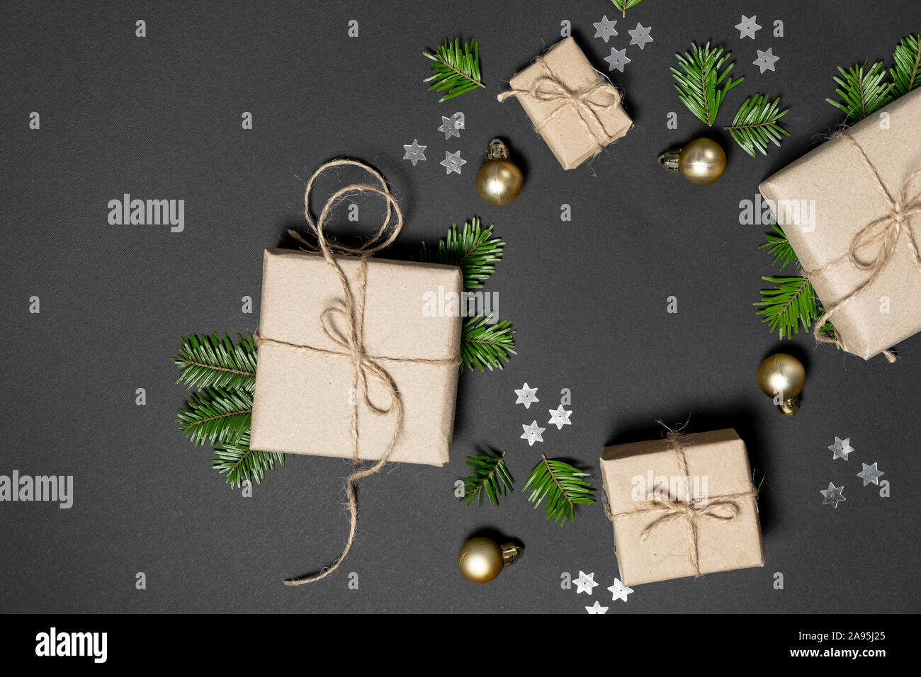 Composition d'hiver ou de noël. Cadeaux faits à la main avec du papier craft décorée de branches de sapins et les confettis sur fond sombre. Télévision lay, top vi Banque D'Images
