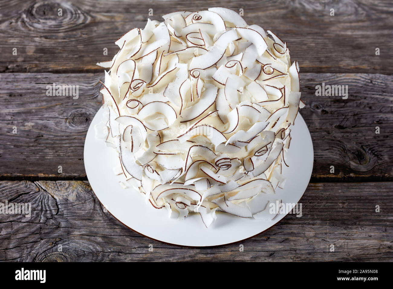 Style rustique d'une noix de coco gâteau décoré avec des rubans de noix de coco, close-up Banque D'Images