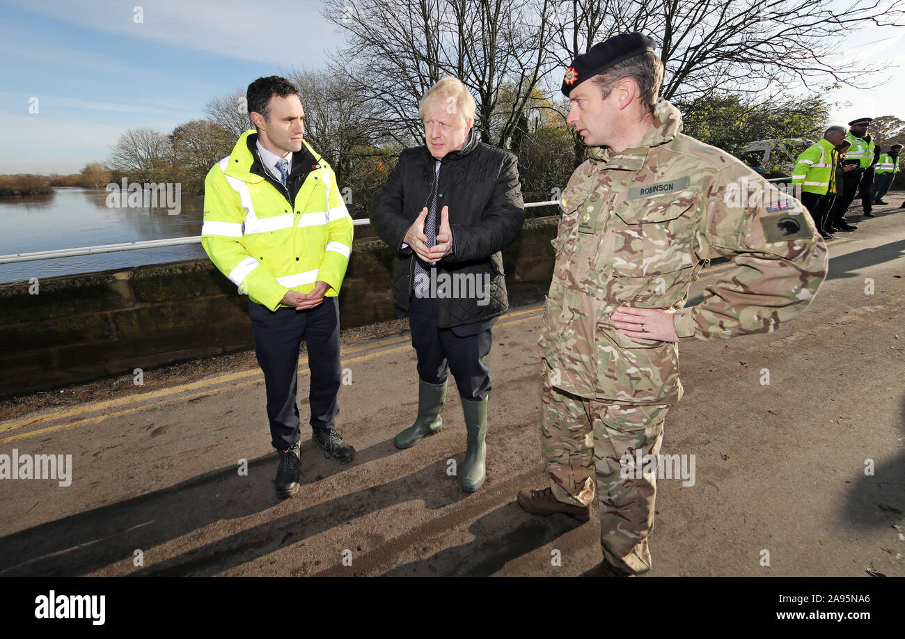 Premier ministre Boris Johnson promenades avec le Lt Col Tom Robinson, de la Light Dragoons et un organisme chargé de l'environnement au cours d'une visite officielle à Stainforth, Doncaster, à voir les récentes inondations. Banque D'Images