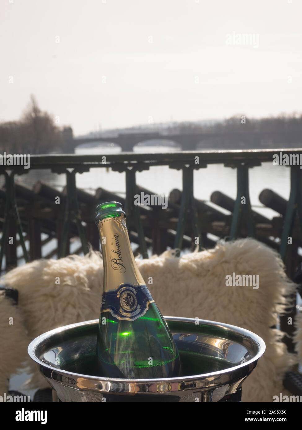 Restaurant en plein air avec vue sur la rivière Vltava, ensoleillée, ciel bleu et une bouteille de vin pétillant de Bohème, printemps de Prague République Tchèque Banque D'Images