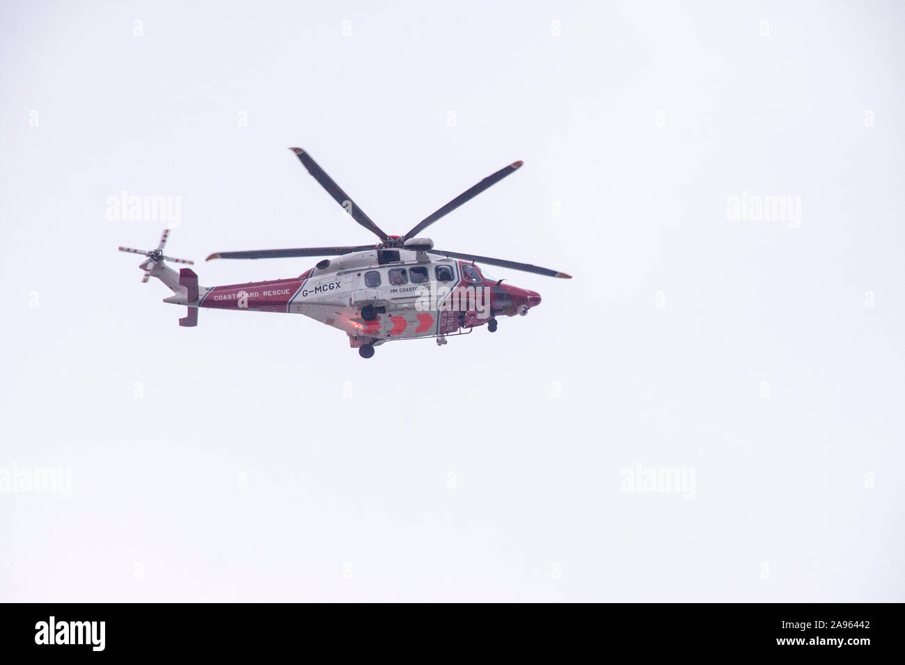 Hélicoptère de sauvetage de la Garde côtière en action plus de Sidmouth, Devon, UK Banque D'Images