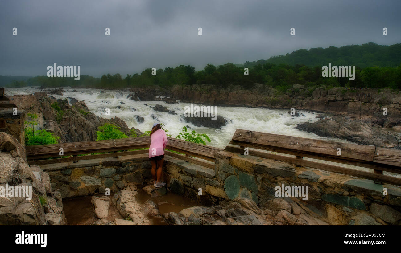 Woman in pink sweater debout devant des eaux Grand Falls National Park sur un jour nuageux orageux Banque D'Images