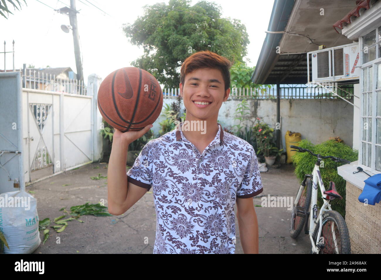 Adolescent qui aime le basket-ball puis il sourit, asian teenage boy holding a ball, teen boy, basket-ball garçons, jeune homme baskketball, hommes basketbal Banque D'Images