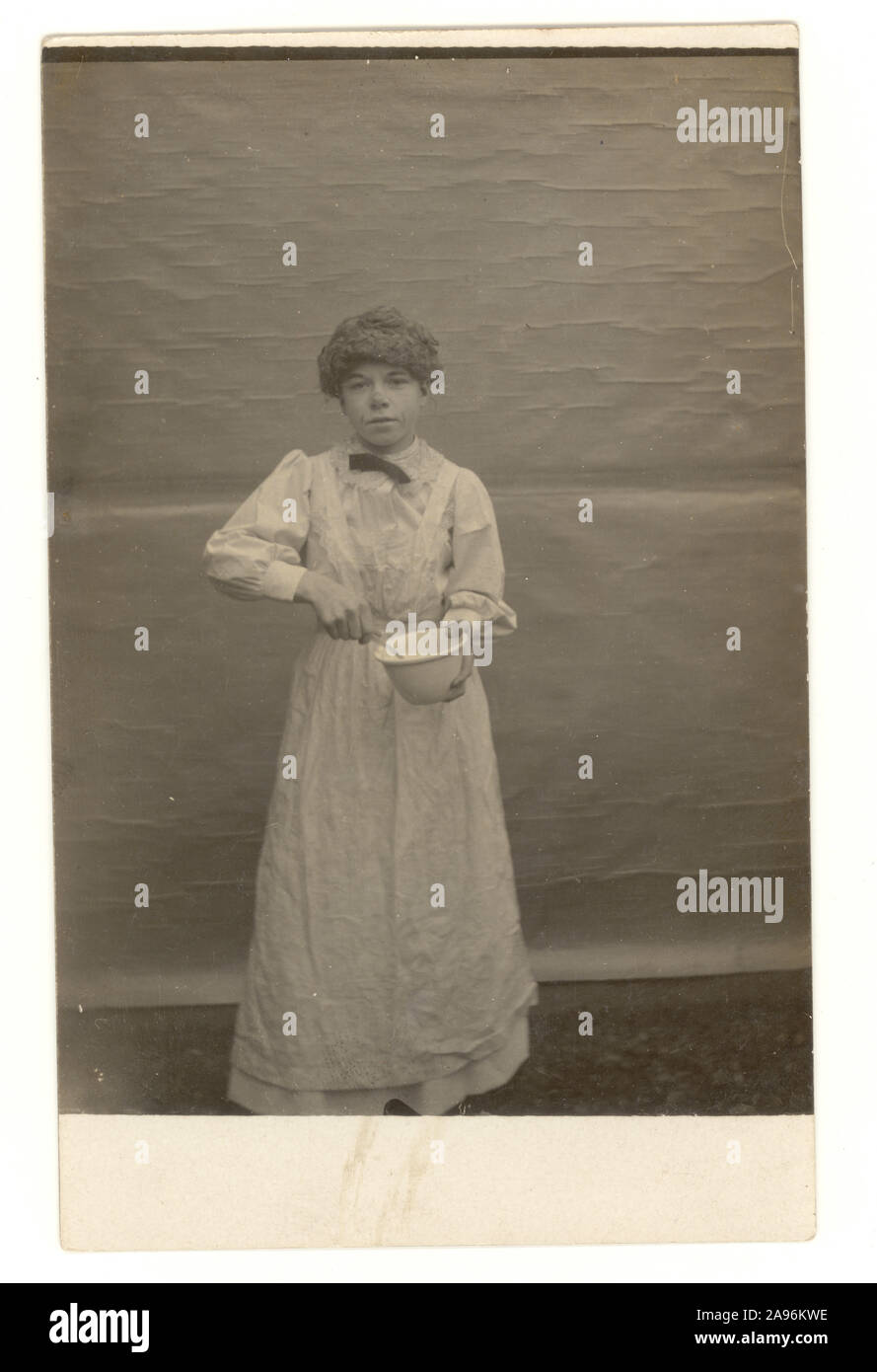 Début des années 1900 Carte postale de l'enfant en robe de costume de femme de chambre, de cuisine ou d'intérim cadre, vers 1910, Royaume-Uni Banque D'Images