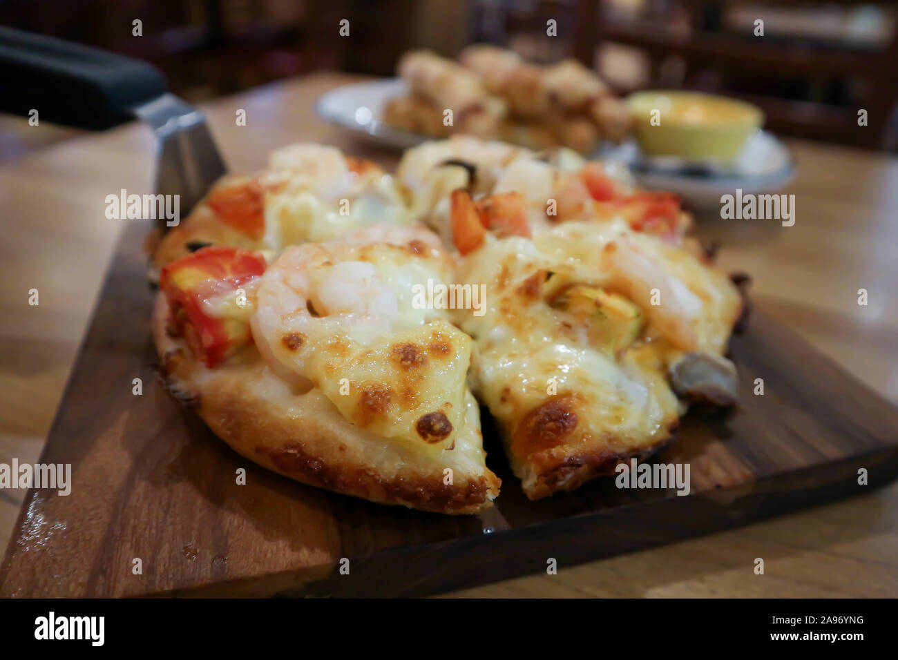 Pizza aux crevettes ou aux fruits de mer pizza dans le plateau en bois Banque D'Images