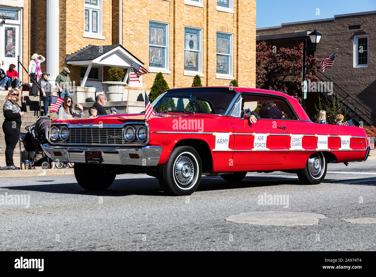 LINCOLNTON, NC, USA-11 nov 2019 : Chevrolet Impala 1964 Rouge conduit en défilé d'anciens combattants, avec panneaux imprimés en disant : "Army", "Air Force", "Coast Guard" Banque D'Images