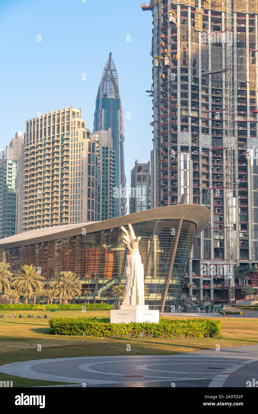 La statue de la main à Burj Park avec l'Opéra de Dubaï et de la construction à l'arrière-plan. Banque D'Images