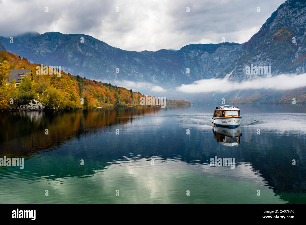 Une excursion en bateau sur un lac calme avec Bohinj couleur des feuilles d'automne, la Slovénie, l'Europe. Banque D'Images