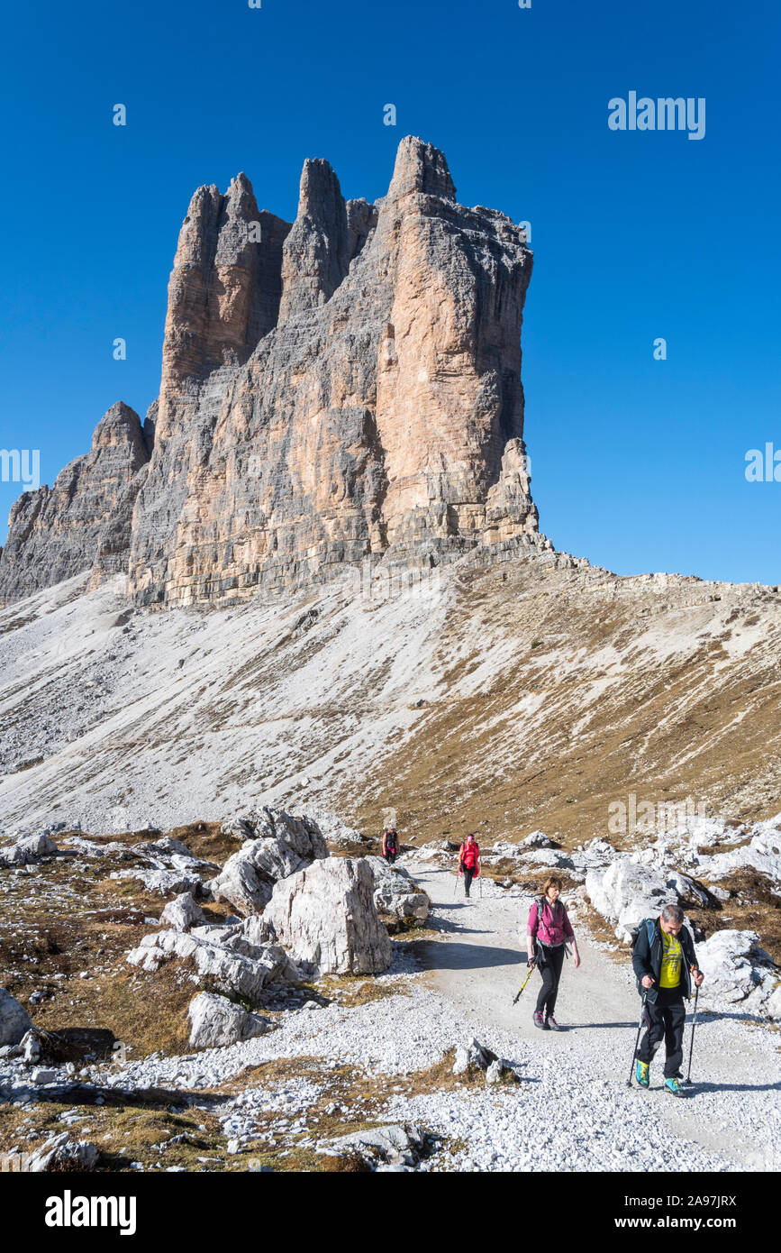 Quatre touristes marcher sous la face sud de Tre Cime di Lavaredo / Drei Zinnen, des pics de montagne dans les Dolomites de Sexten, Sesto / Tyrol du Sud, Italie Banque D'Images