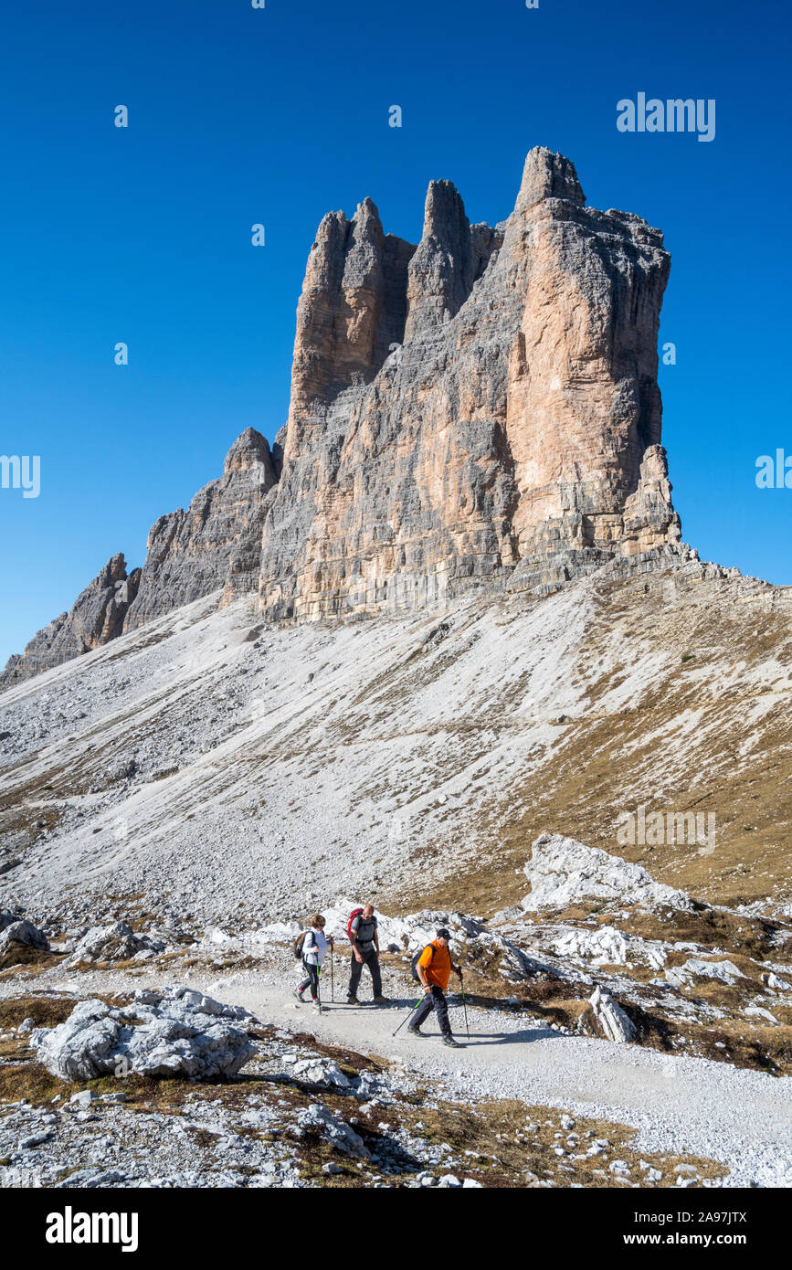 Trois touristes marcher sous la face sud de Tre Cime di Lavaredo / Drei Zinnen, des pics de montagne dans les Dolomites de Sexten, Sesto / Tyrol du Sud, Italie Banque D'Images