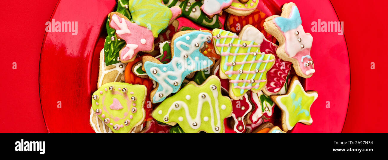 Gingerbread cookies de Noël Noël rouge sur la plaque. Châssis long horizontal Banque D'Images