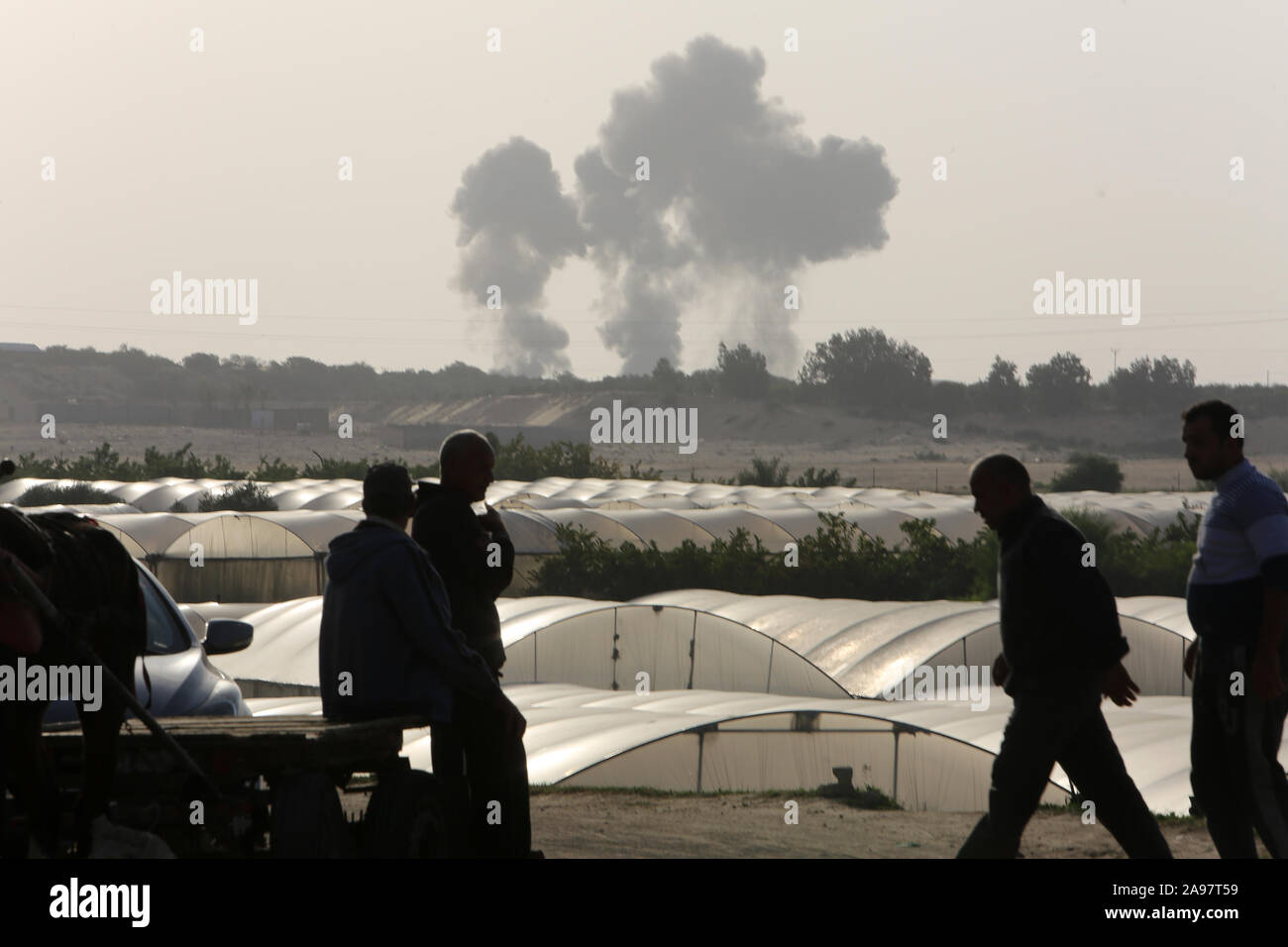 Palestiniens regarder la fumée s'élevant après une frappe aérienne israélienne à Khan Younis dans le sud de la bande de Gaza, le 13 Nov 2019. Photo par Abed Rahim Khatib Banque D'Images