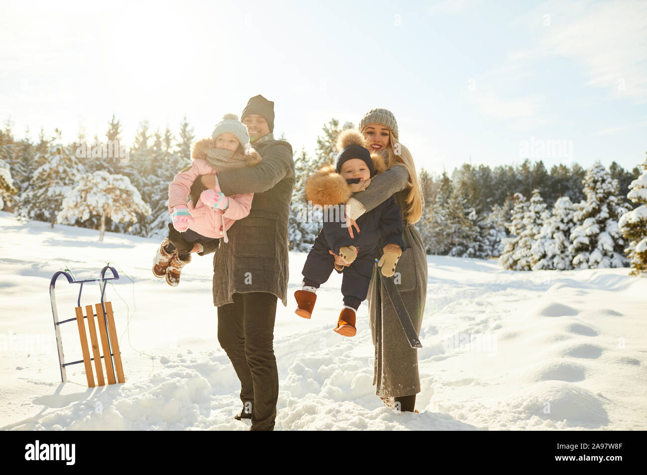 Playful couple avec enfants en hiver woods Banque D'Images