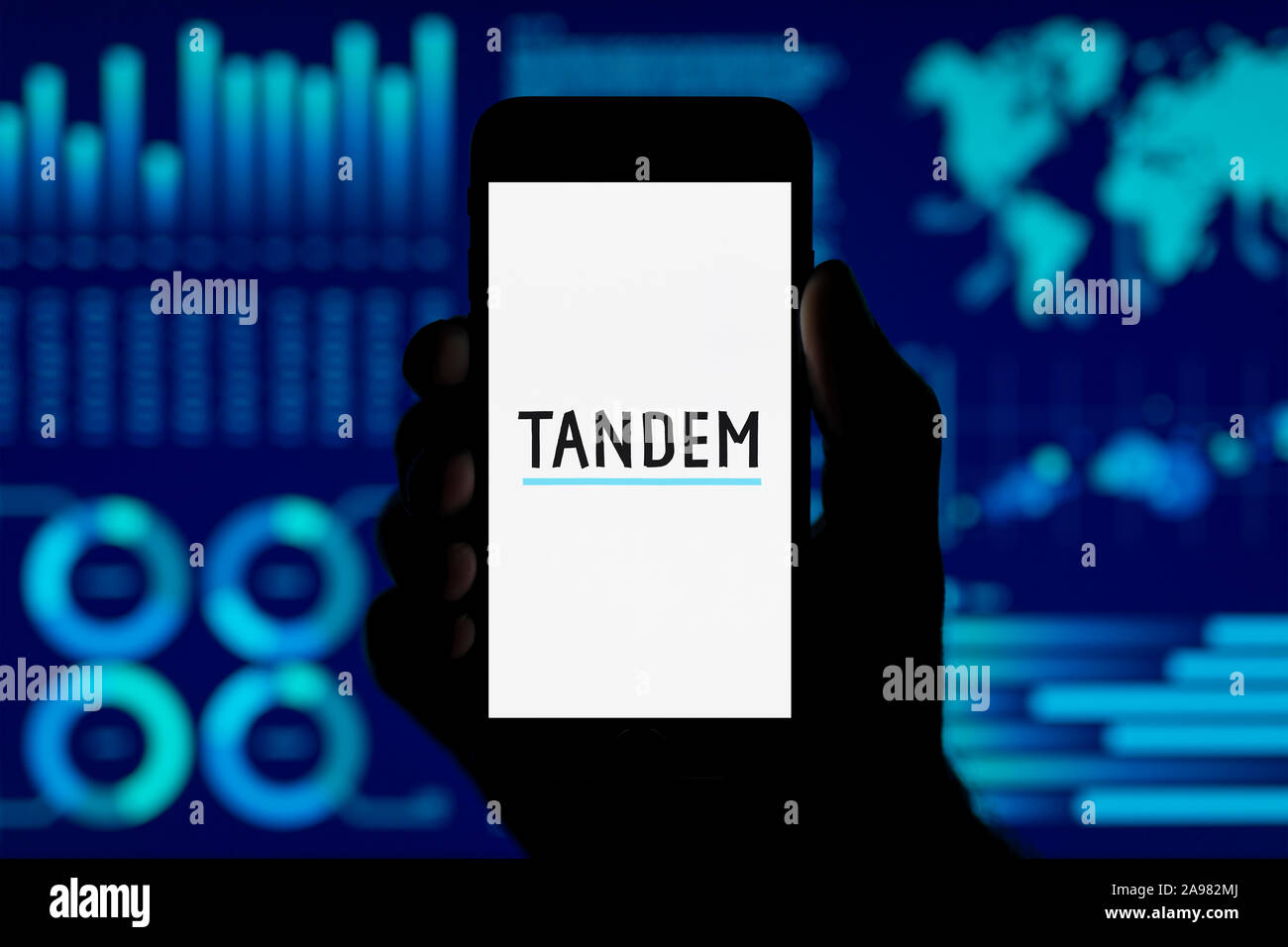 Un homme est titulaire de l'iPhone qui affiche le logo de l'argent en tandem, tourné dans un style de visualisation de données (fond usage éditorial uniquement). Banque D'Images Un homme est titulaire de l'iPhone qui affiche le logo de l'argent en tandem, tourné dans un style de visualisation de données (fond usage éditorial uniquement). Banque D'Images