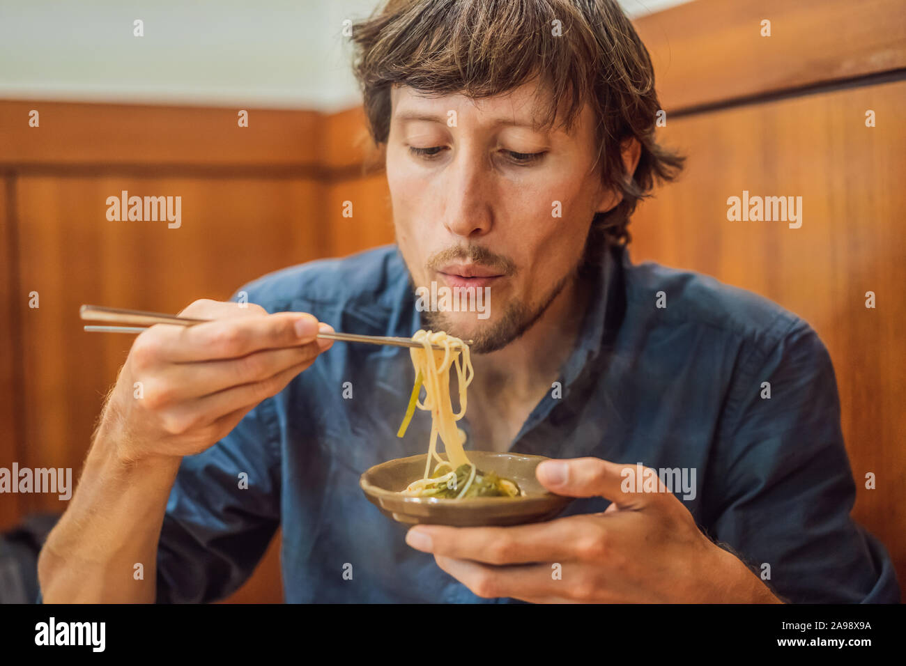 L'homme de manger des nouilles Coréen Coréen dans un café. Billet Corée Concept Banque D'Images