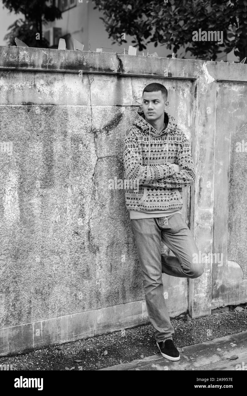 Jeune homme asiatique multiethnique à l'extérieur en noir et blanc Banque D'Images