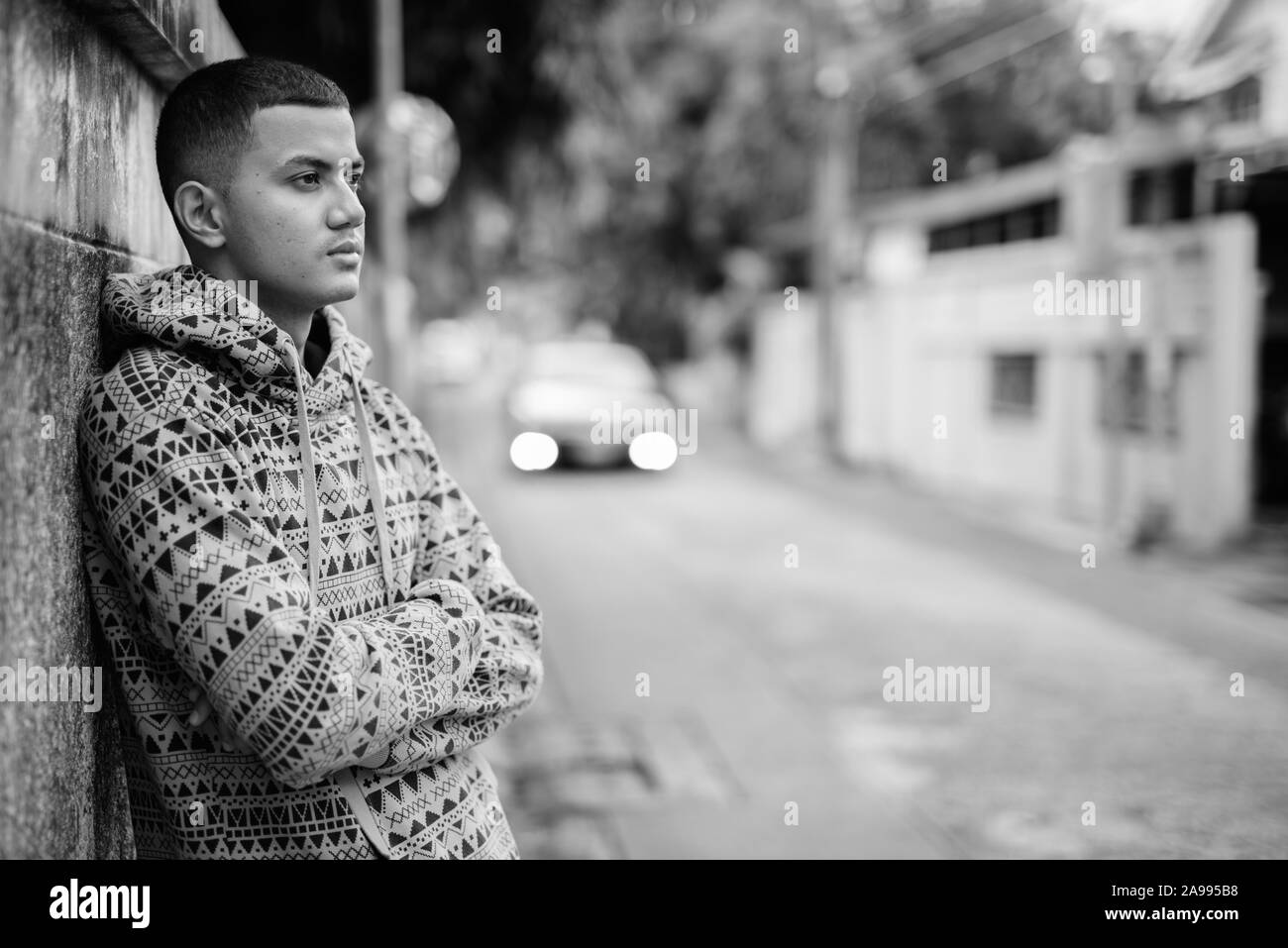 Jeune homme asiatique multiethnique à l'extérieur en noir et blanc Banque D'Images
