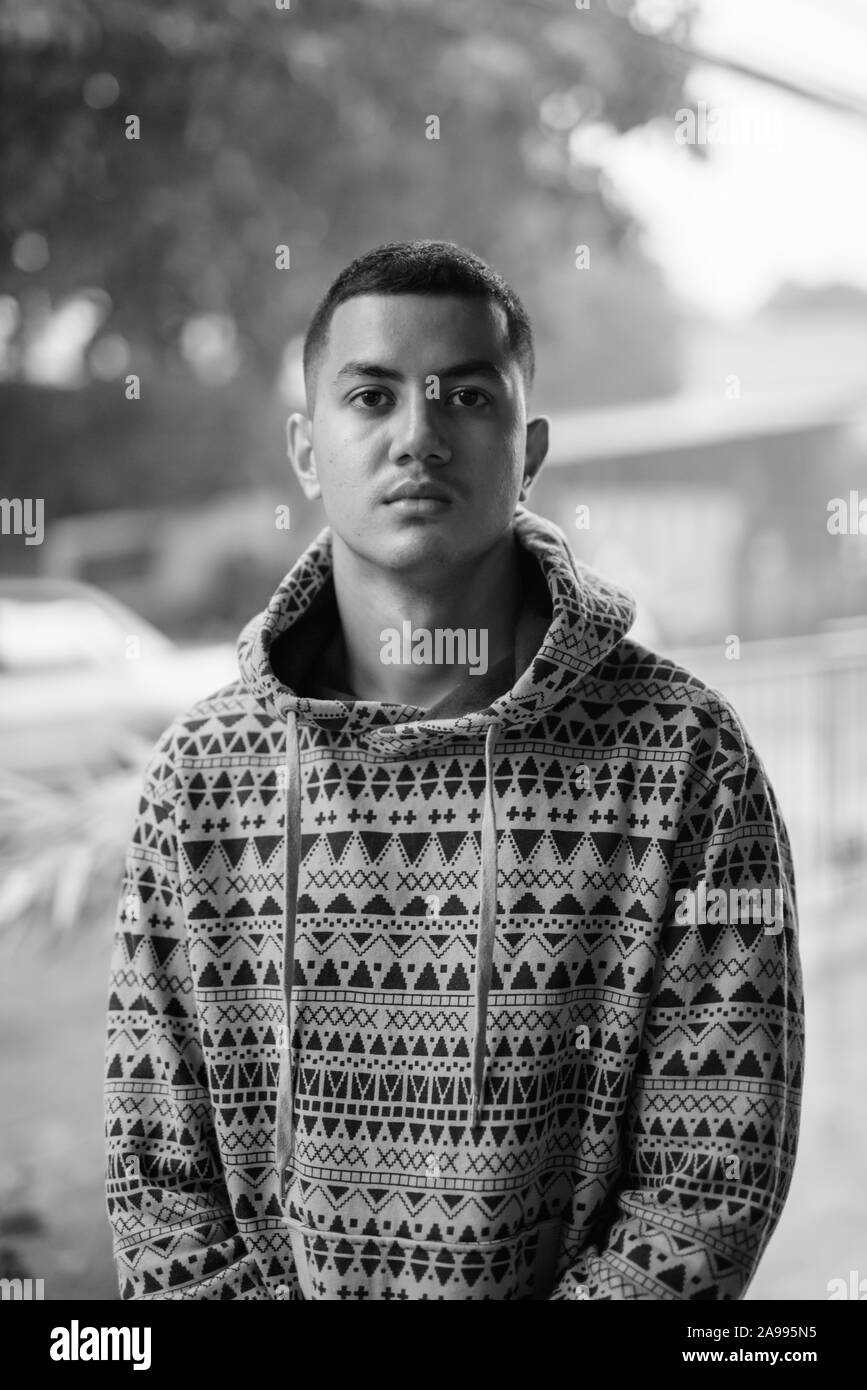 Jeune homme asiatique multiethnique à l'extérieur en noir et blanc Banque D'Images