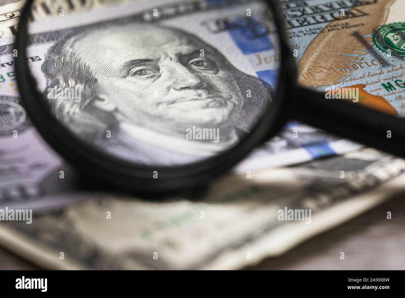 Concept sur le thème du contrôle de l'argent pour l'authenticité. Benjamin Franklin regarde à travers une loupe dans le châssis Banque D'Images