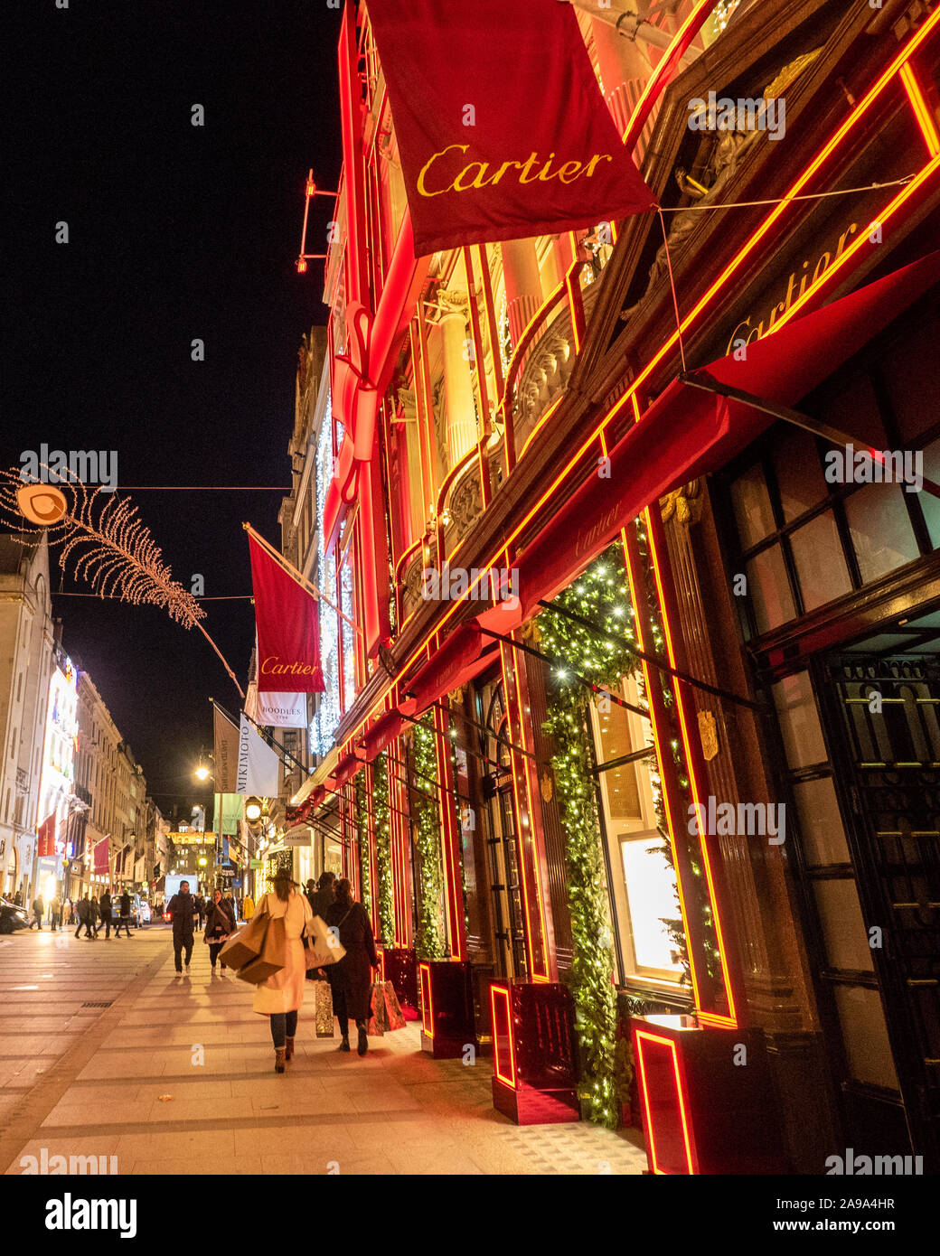 Décorations de Noël sur New Bond Street à Londres avec la façade rouge de Cartier. Banque D'Images