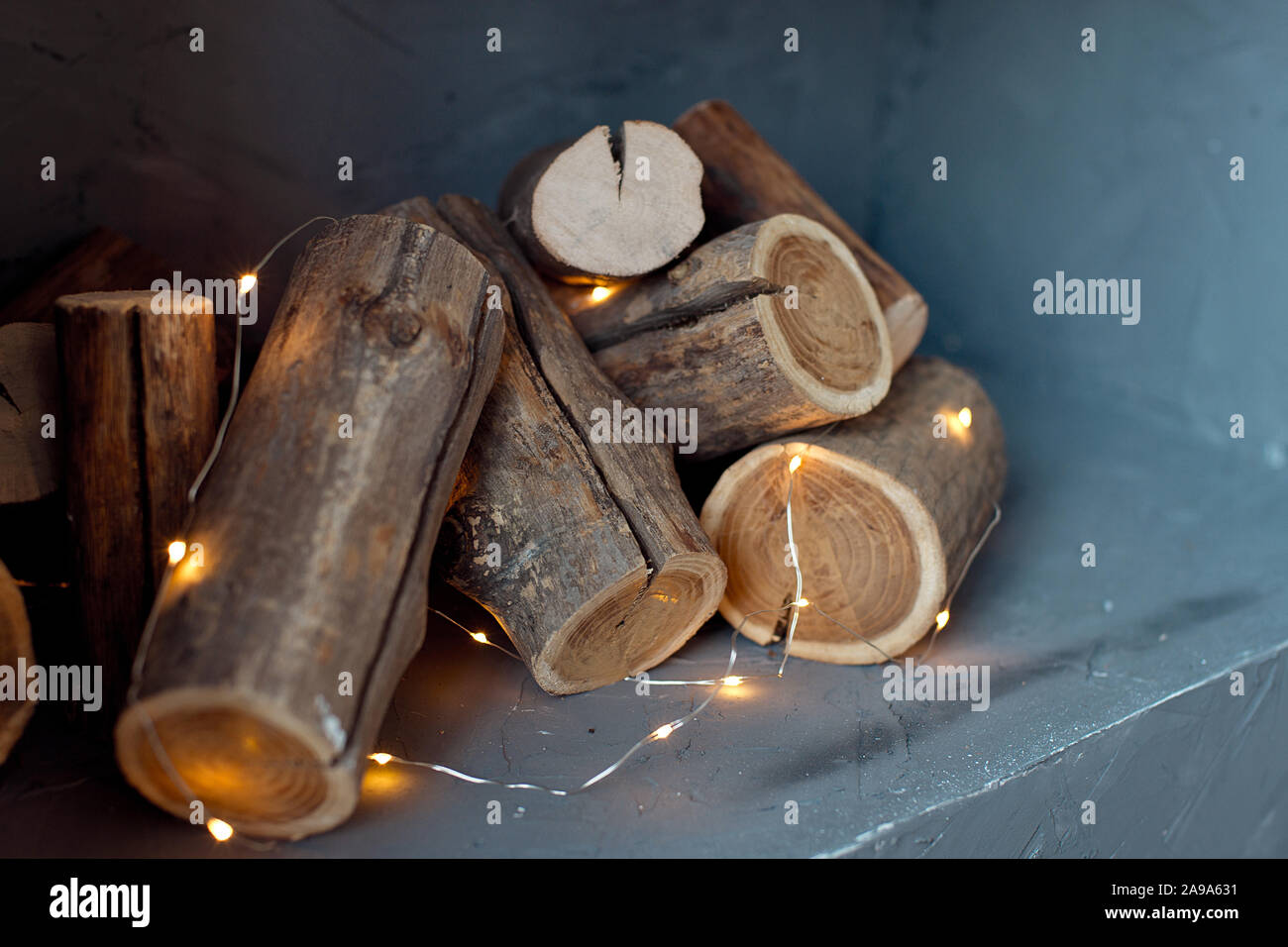 Sciage d'un arbre sont situé sur le mur. Imitation d'une cheminée dans le mur, les lumières d'une guirlande avec les journaux Banque D'Images