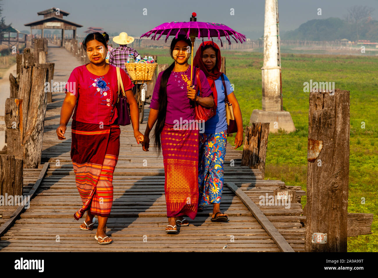 Un groupe de femmes traversant le pont U Bein, Amarapura, Mandalay, Myanmar. Banque D'Images