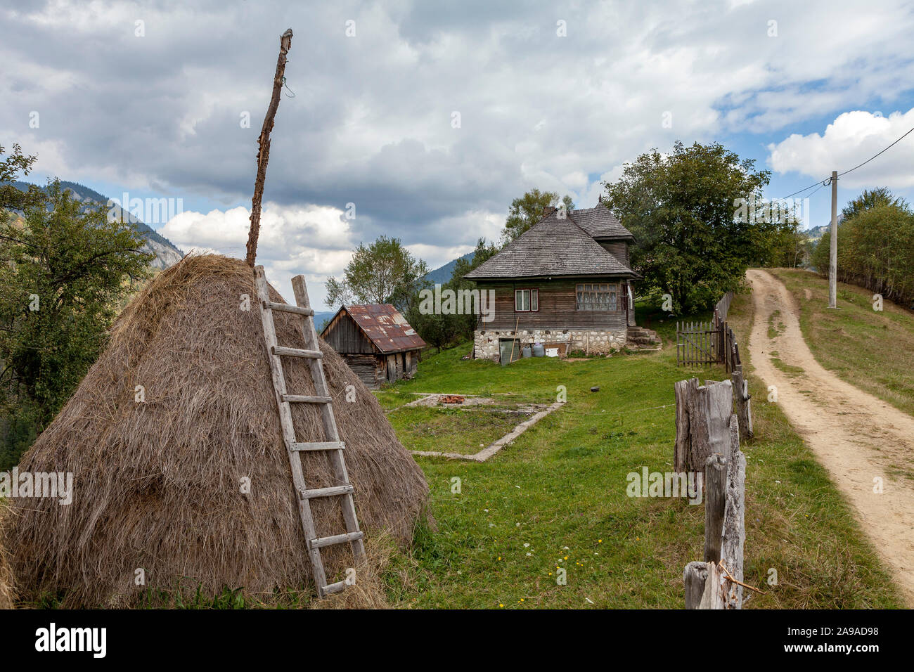 Une ferme isolée dans les collines de Transylvanie avec un traditionnel haystack, Roumanie Banque D'Images