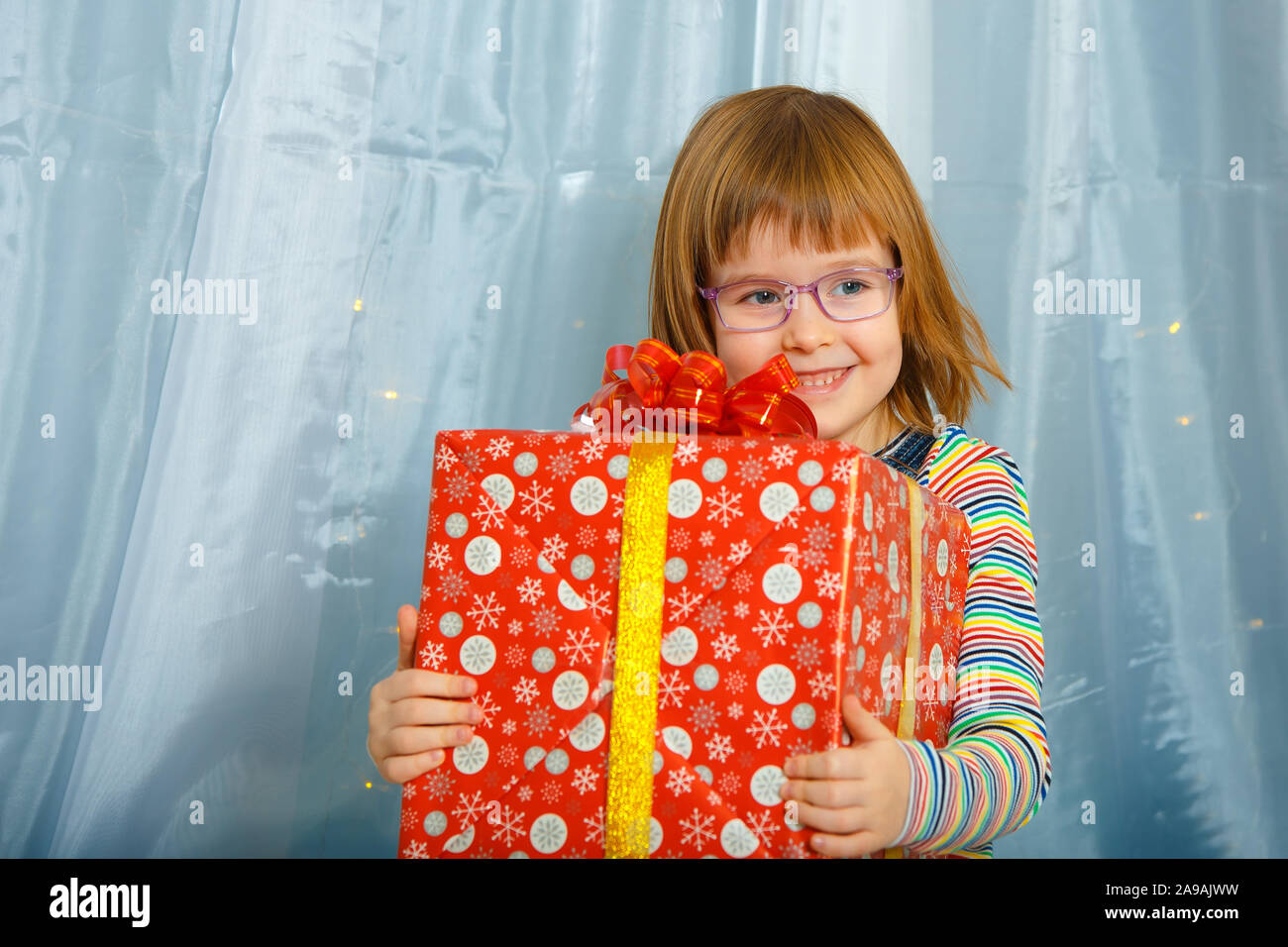 Masha fille tenant une boîte avec un cadeau et smiling Banque D'Images