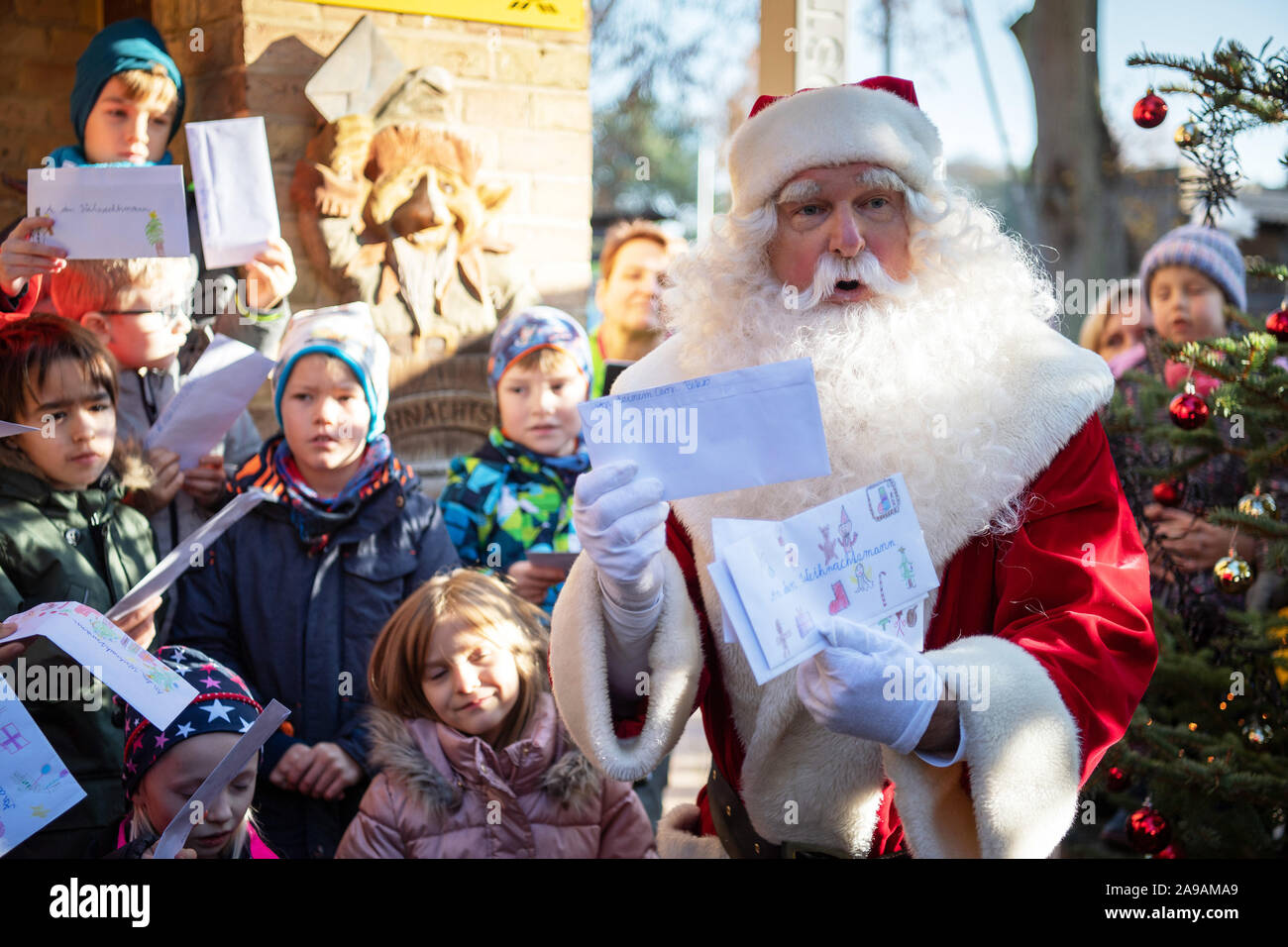 Flensburg, Allemagne. 14Th Nov, 2019. Après son arrivée en face de l'office de poste de Noël, le Père Noël reçoit ses listes de souhaits des enfants de la classe 2a de la DREI Vu Grundschule Fürstenberg. Le Père Noël veut répondre à lettres d'enfants de partout dans le monde d'ici jusqu'à la veille de Noël. Jusqu'à présent environ 6000 lettres sont arrivés au bureau de poste. Credit : Soeren Stache/dpa-Zentralbild/dpa/Alamy Live News Banque D'Images