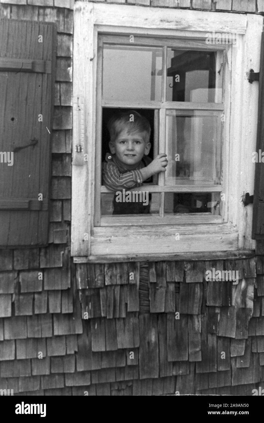 Un petit garçon regardant par la fenêtre, l'Allemagne des années 1930. Banque D'Images