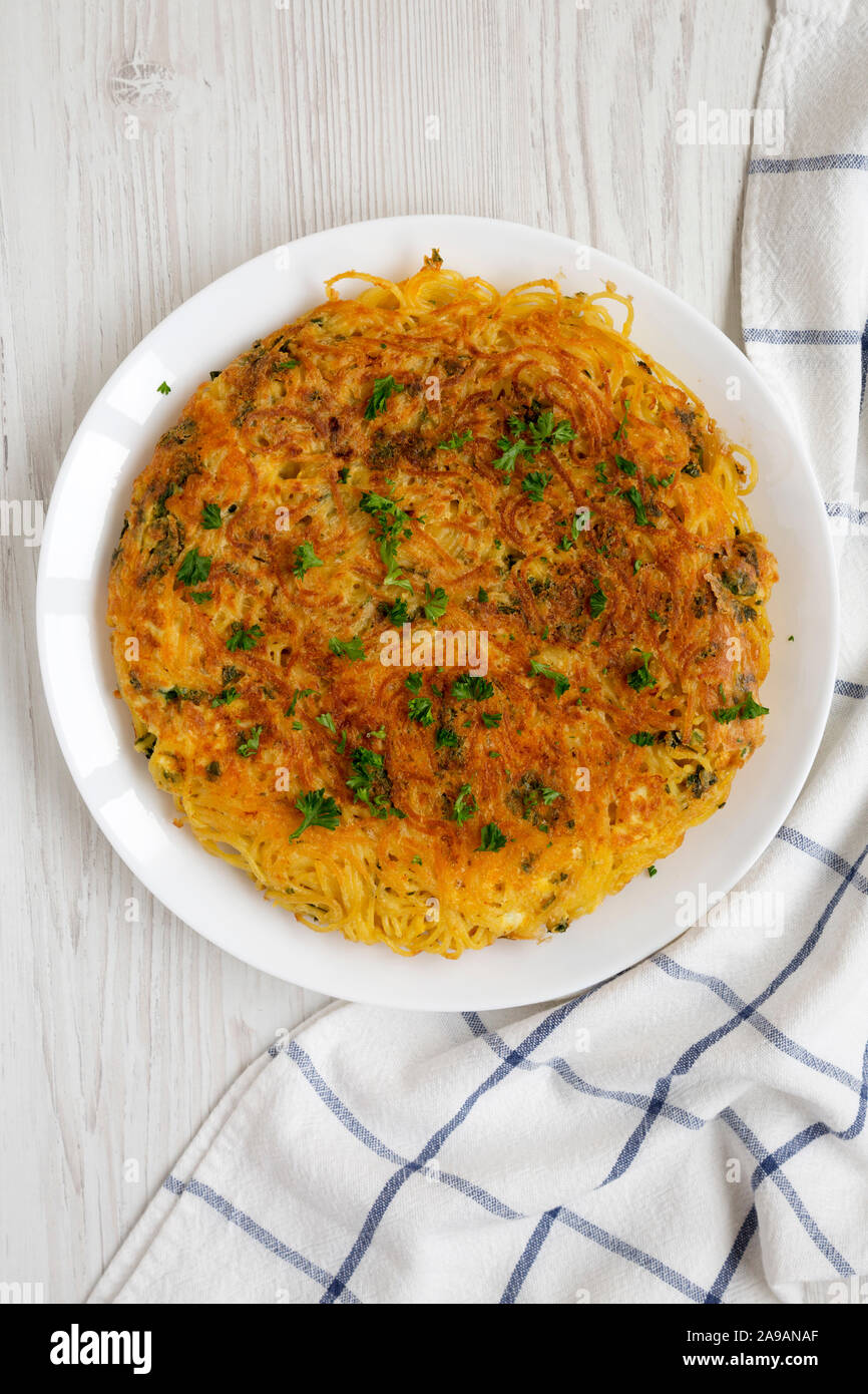 Spaghetti maison omelette sur une assiette blanche sur fond de bois blanc, vue du dessus. Mise à plat, les frais généraux, d'en haut. Banque D'Images