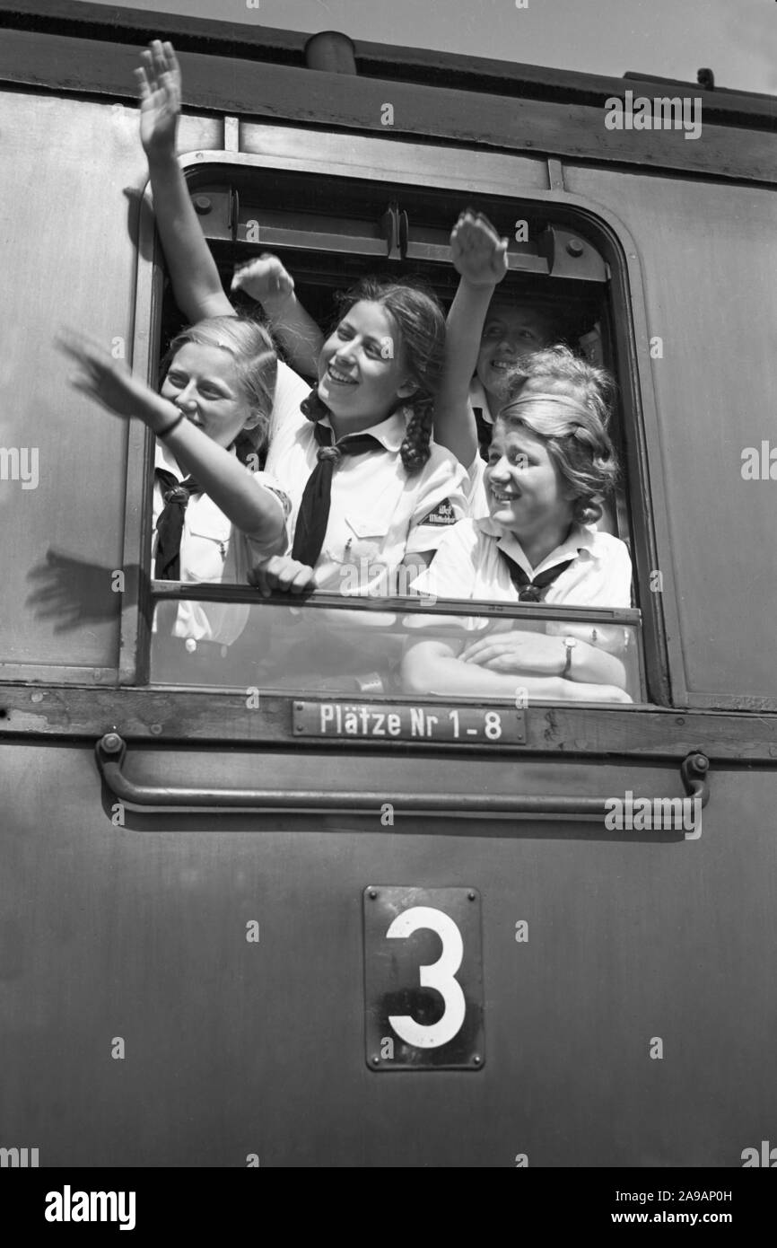 Filles oout BdM acclamations de la fenêtre de leur train de les prendre à leurs vacances, Allemagne 1930. Banque D'Images