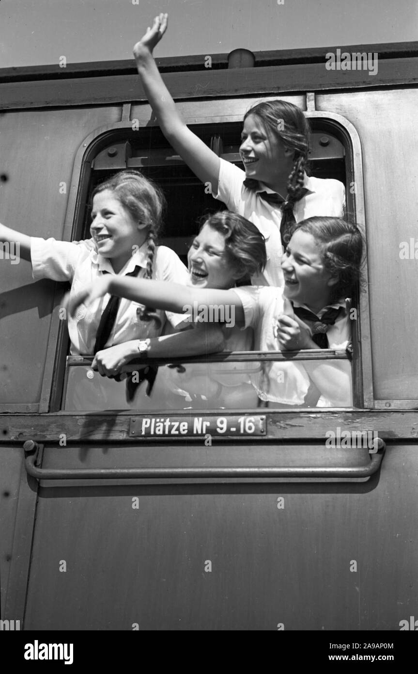 Filles oout BdM acclamations de la fenêtre de leur train de les prendre à leurs vacances, Allemagne 1930. Banque D'Images