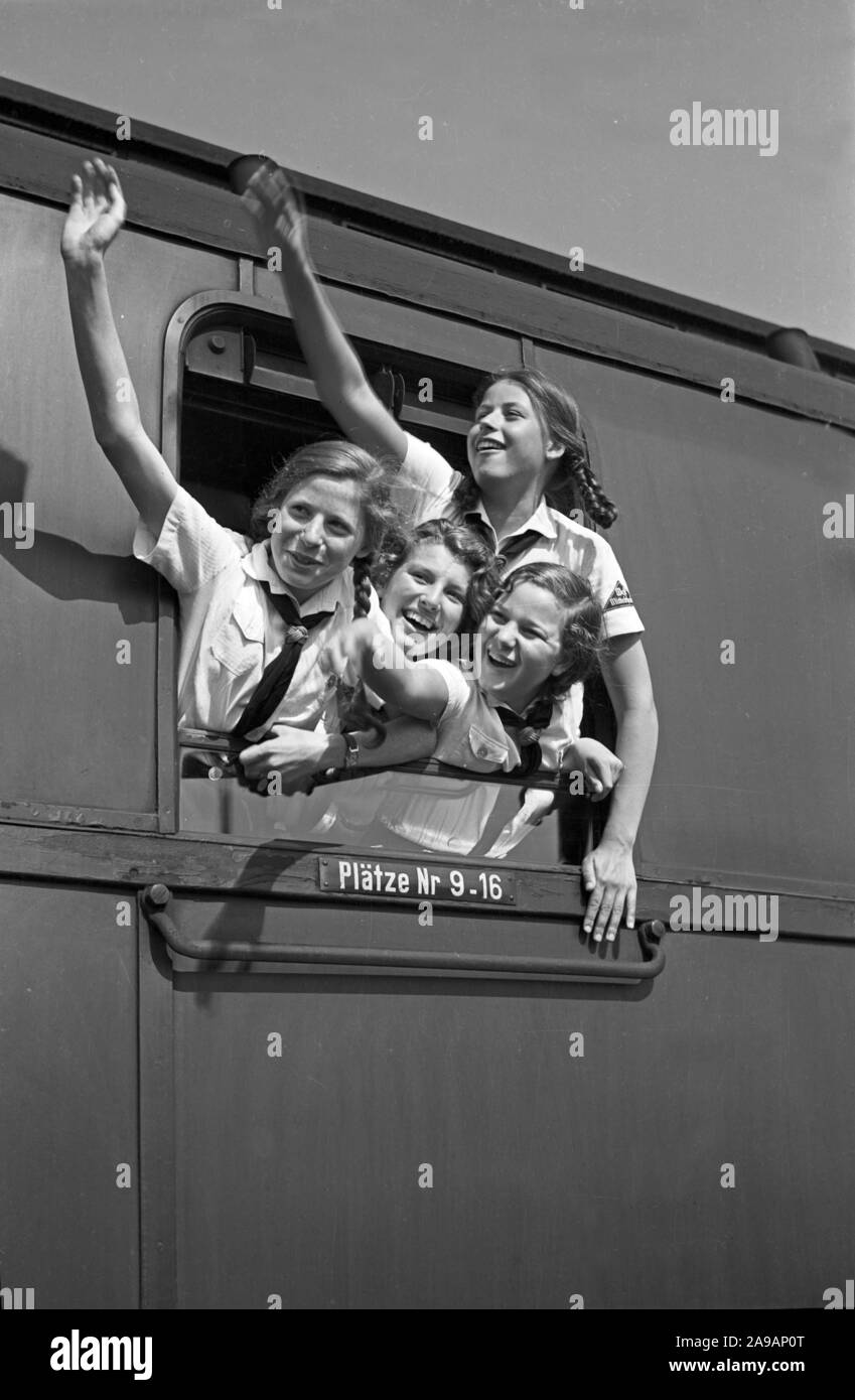 Filles oout BdM acclamations de la fenêtre de leur train de les prendre à leurs vacances, Allemagne 1930. Banque D'Images