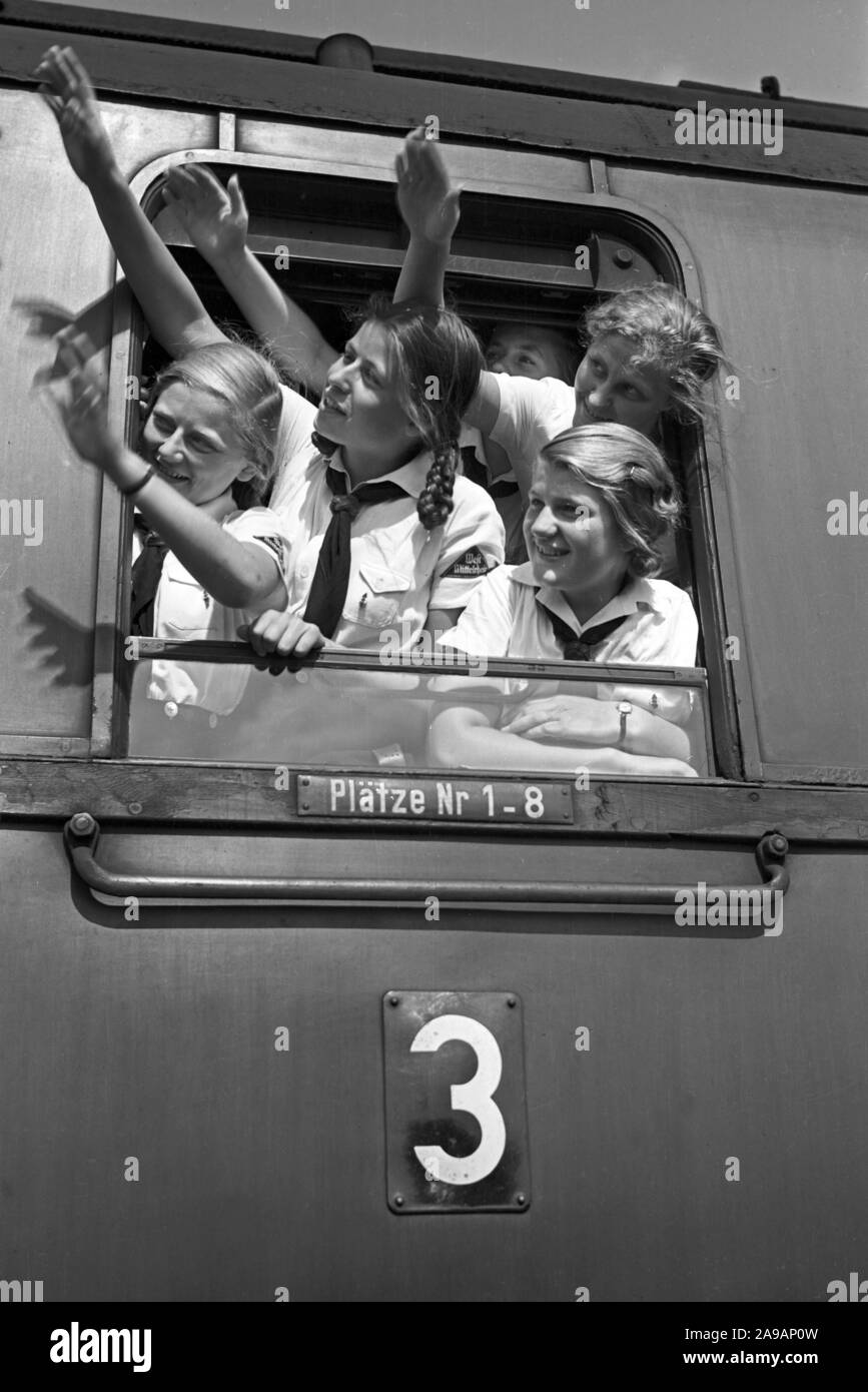 Filles oout BdM acclamations de la fenêtre de leur train de les prendre à leurs vacances, Allemagne 1930. Banque D'Images