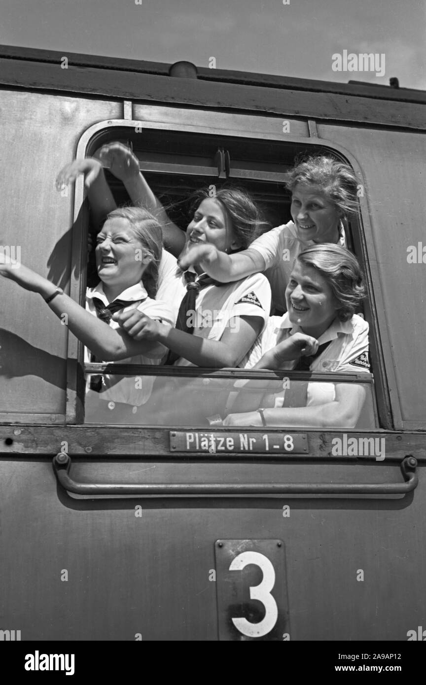 Filles oout BdM acclamations de la fenêtre de leur train de les prendre à leurs vacances, Allemagne 1930. Banque D'Images