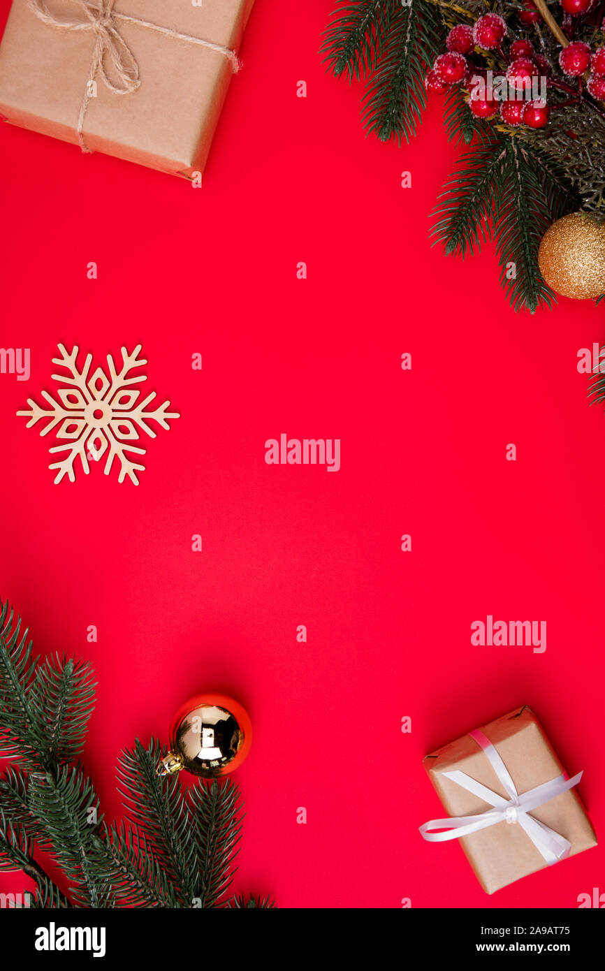 Haut au-dessus de l'angle vertical haut voir photo de l'espace vide entre les branches de sapin et cadeaux flocon avec des jouets de Noël fond rouge vif couleur isolé Banque D'Images