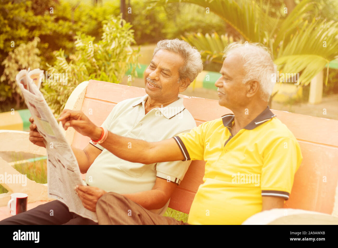 Deux professionnels senior men reading newspaper at park outdoor - personnes âgées bénéficiant d'amis moring news - Concept de vie heureuse des hommes plus âgés. Banque D'Images