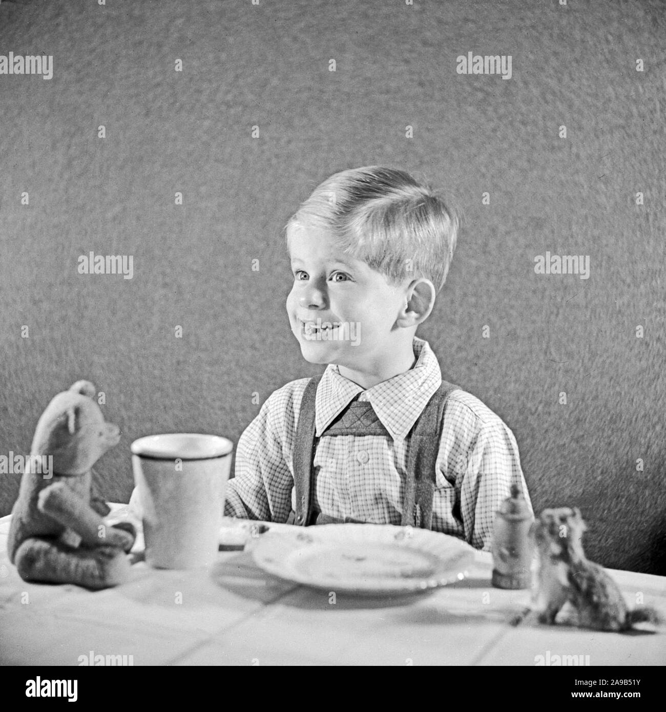 Un petit garçon en train de manger son pain et beurre, Allemagne 1951 Banque D'Images