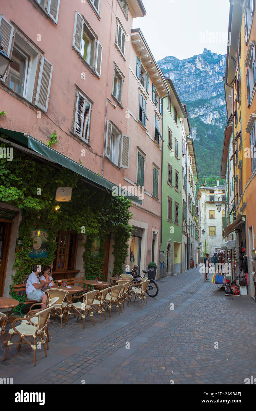Un couple s'asseoir dans une zone piétonne tranquille, bénéficiant d'une 'All'aperto' apéritif : Via Santa Maria, Riva del Garda, Trentino, en Italie Banque D'Images