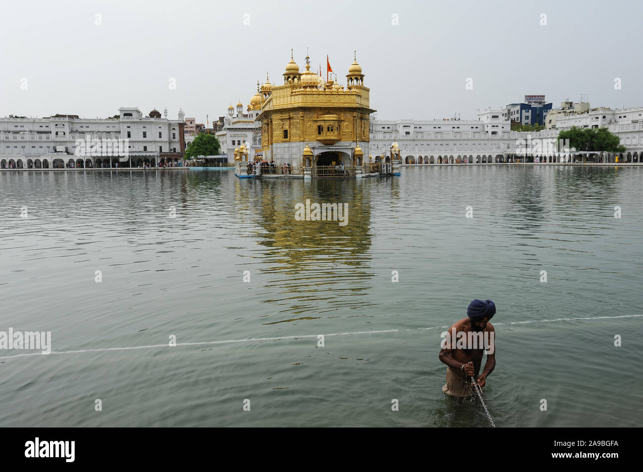 22.07.2011, Amritsar, Punjab, India - un croyant se baigne dans la sainte sikhe du bassin de l'eau (l'Amrit) Sarover du Temple d'Or, le plus grand sanctuaire de t Banque D'Images