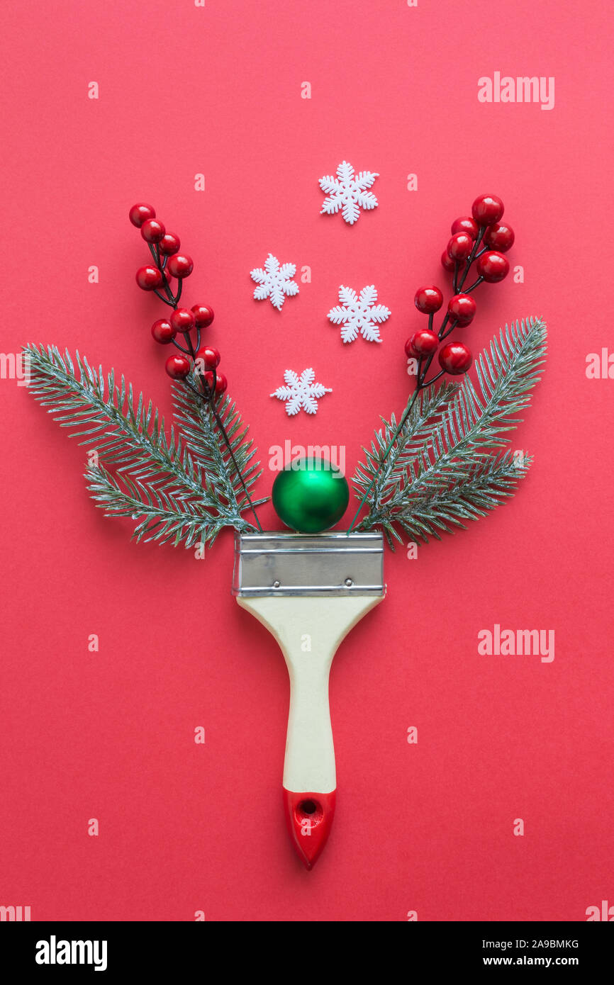 Mise à plat d'un pinceau avec des branches d'arbre de Noël, décoration babiole, flocons et fruits rouges un minimum de créativité concept. Banque D'Images