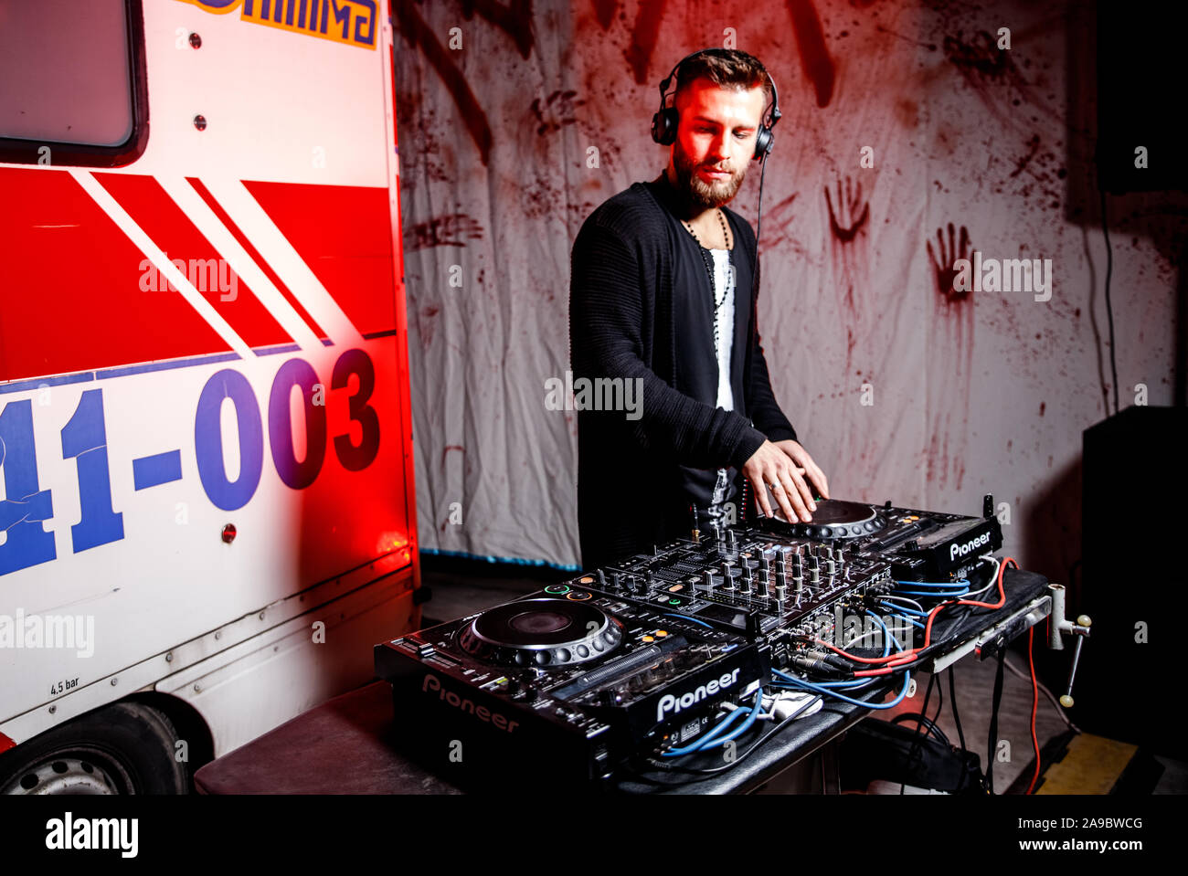 L'Ukraine, le 26 octobre 2019:jeune homme avec un casque DJ travaille sur le contrôle de la platine de mixage console de mixage console DJ, disc-jockey, DJ, console, Banque D'Images