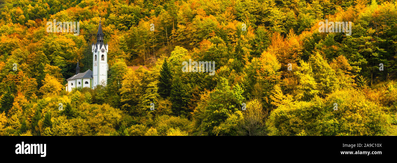 L'Église catholique de Sainte Marie avec la couleur des feuilles d'automne dans les collines au-dessus de Kropa, la Slovénie, l'Europe. Banque D'Images