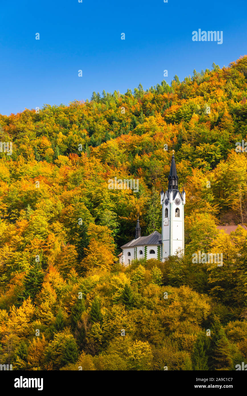 L'Église catholique de Sainte Marie avec la couleur des feuilles d'automne dans les collines au-dessus de Kropa, la Slovénie, l'Europe. Banque D'Images